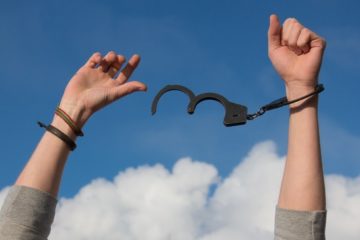 hands freeing themselves from handcuffs