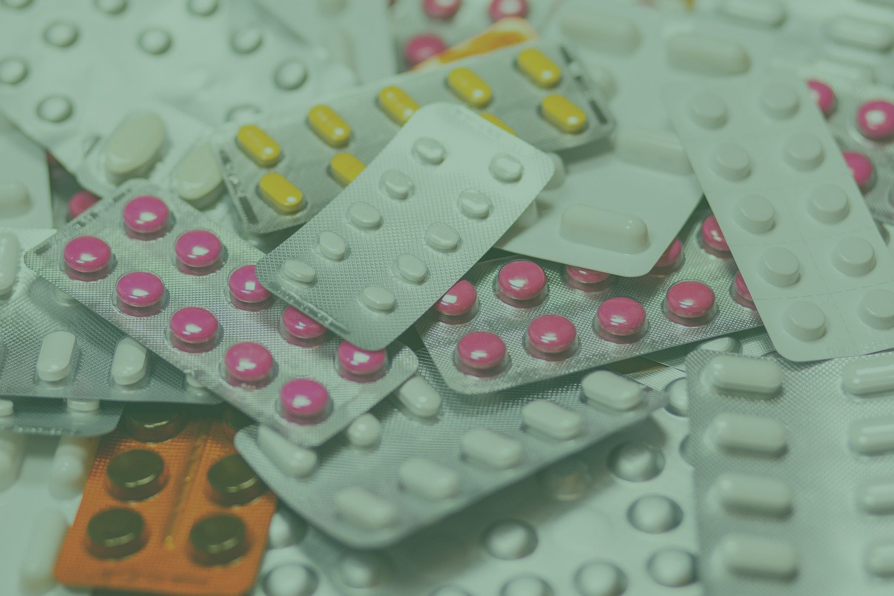 piles of tablets and capsules packaged in plastic